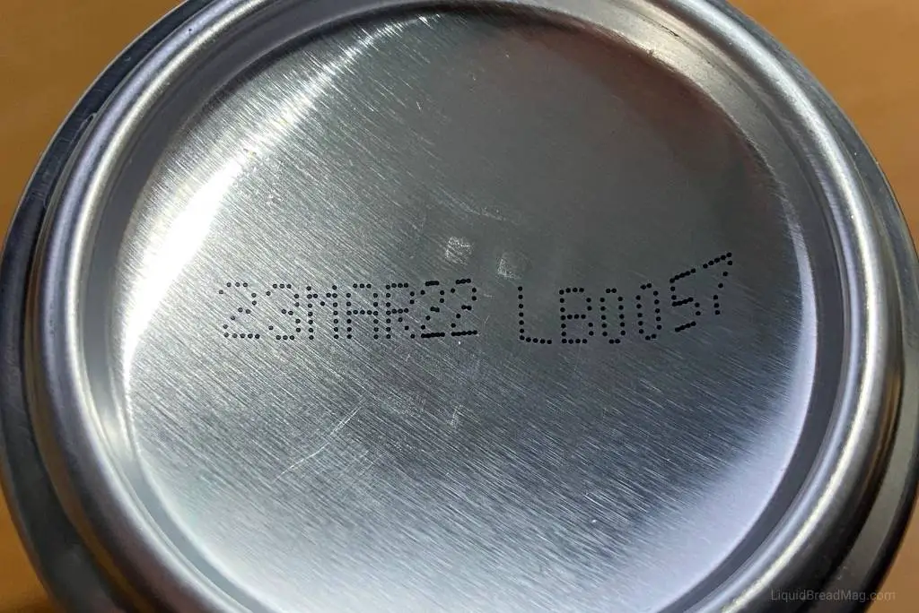 Expiration date stamped on the bottom of a can of beer.