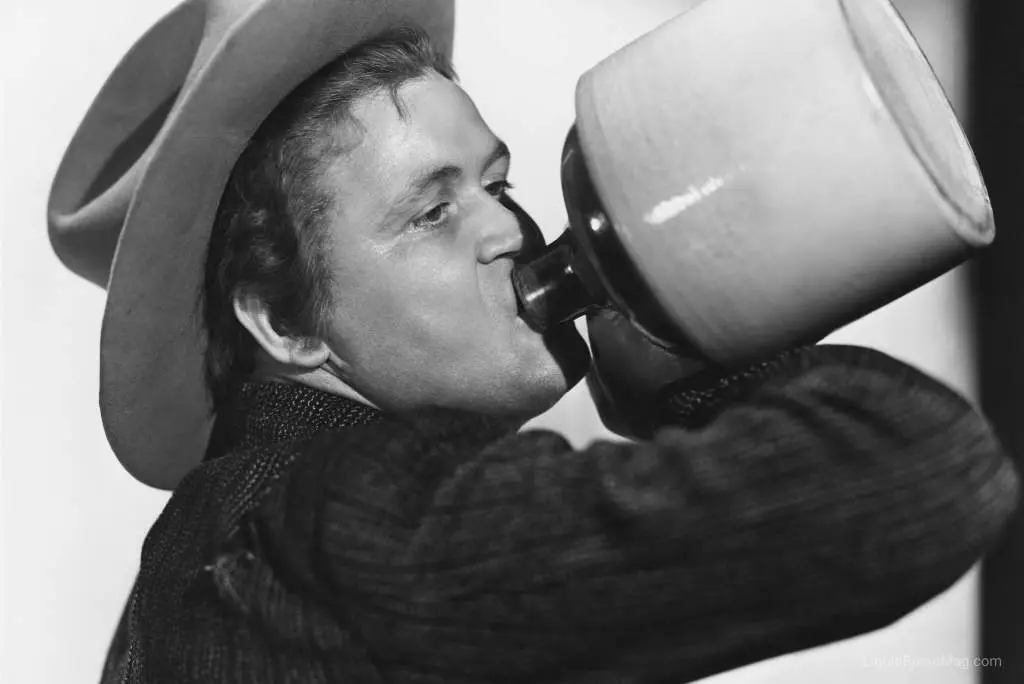 Cowboy drinking out of a moonshine jug.